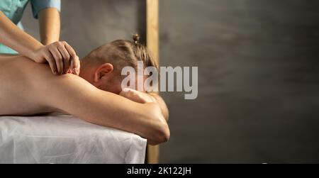 Handsome man enjoying back massage at spa salon. Relaxing massage at the spa. Banner Stock Photo