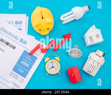 Living cost increase, economic crisis flat lay. Shopping cart utilities bills and red rising up arrow on green background. Stock Photo