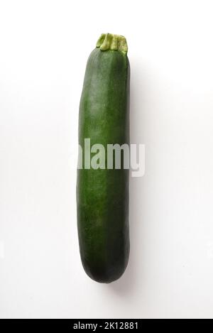 Detail of whole zucchini isolated white on table. Vertical composition. Stock Photo
