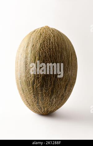 Detail of ripe green melon on white table with white isolated background. Front view. Vertical composition. Stock Photo