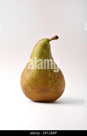 Detail of whole ripe green and brown pear isolated on white table. Vertical composition. Stock Photo