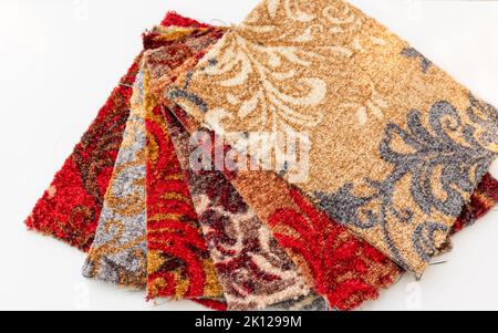 Multi colors carpets pieces display for sale in the store on white isolated background Stock Photo