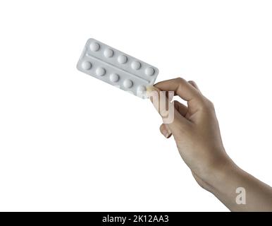 a blister pack of pills in the female hand on a white background Stock Photo