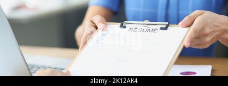 Person submits resume to an employer at interview Stock Photo