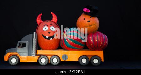 large children's toy car truck loaded with beautiful decorative pumpkins. Preparation delivery of decor for Halloween holiday. Festive decoration. del Stock Photo