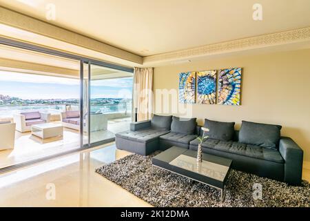 a view of a comfy sofa next to a balcony with Mediterranean views of the Spanish coastline Stock Photo