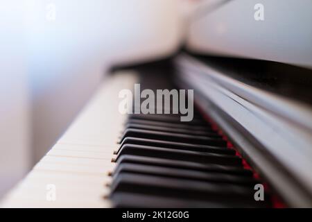 Classic grand piano keyboard close-up. Close-up of a wooden piano and piano keys. Selective focus and soft focus. Frontal view, shallow depth of field Stock Photo