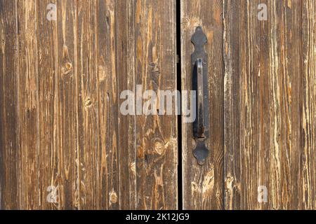 Old doorknob on an old wooden door background at home. Antique background, opening concept. High quality photo Stock Photo