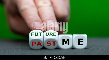 Hand turns dice and changes the expression 'past me' to 'future me'. Stock Photo