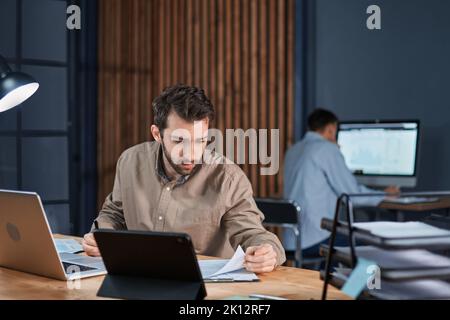 employees working in the office until late at night. Stock Photo