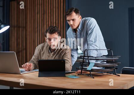 young businessmen working in the office together at night . Stock Photo