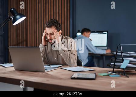 tired businessman working late at night on a new project . Stock Photo