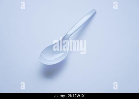 White disposable plastic spoon used for eating isolated on white Stock Photo