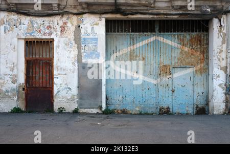 Weathered door to a garage of an abandoned building in Valencia Spain Stock Photo