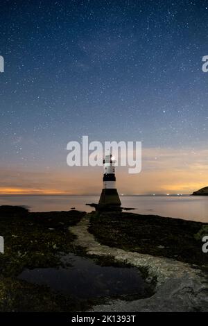 Starry night sky over Trwyn Du lighthouse (Penmon lighthouse), Penmon Point, Anglesey, North Wales, United Kingdom, Europe Stock Photo
