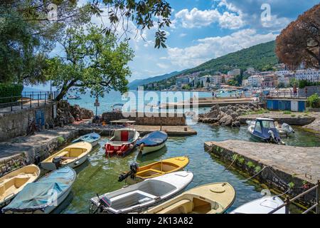 View of rocky inlet and boats with town of Opatija in background, Opatija, Kvarner Bay, Croatia, Europe Stock Photo