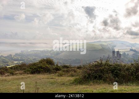 View of the Dorset countryside at Corfe on a misty morning with the castle ruins in the distance, England, UK Stock Photo