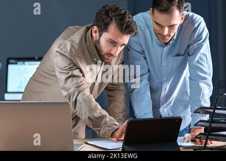 business colleagues using a digital tablet while working on a new project. Stock Photo