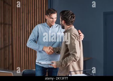 colleagues discussing a business document late at night in the office . Stock Photo
