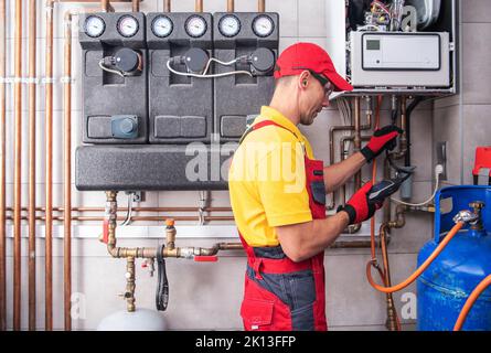 Professional Heating Engineer Making Regular Gas Heating System Performance and Safety Check. Residential Building Heat Installation Maintenance. Stock Photo