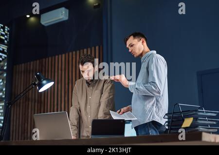 colleagues working working on a new project after hours. Stock Photo