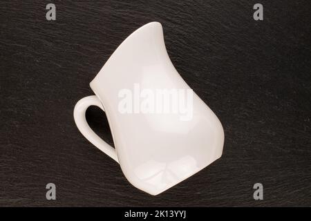 One ceramic milk jug on slate stone, close-up, top view. Stock Photo