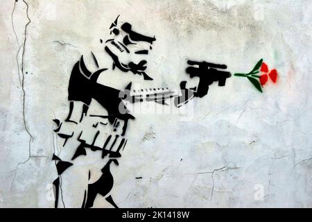 Stormtrooper fires a gun and a red rose comes out, stencil art in Church Street, Runcorn, Halton, Cheshire, England, UK, WA7 1LR Stock Photo