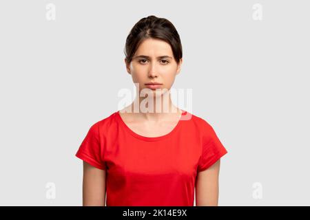 Sad woman portrait. Disappointment regret. Upset lady looking at camera isolated on neutral copy space background. Feeling despair. Lost opportunity. Stock Photo