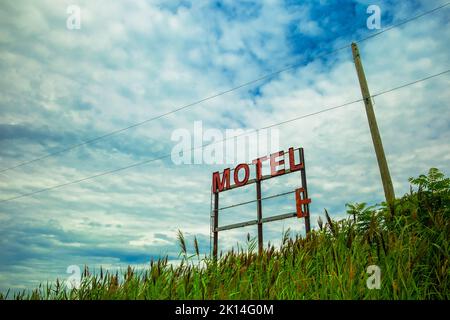 An abandoned motel sign on a cloudy day. Stock Photo