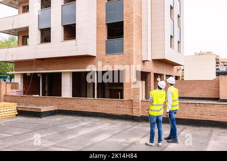 Professional engineers architect workers talking at building construction site Stock Photo