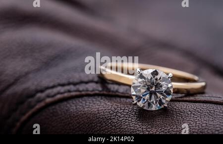 Solitaire Wedding Ring With Round Cut Diamond on Brown Leather Stock Photo
