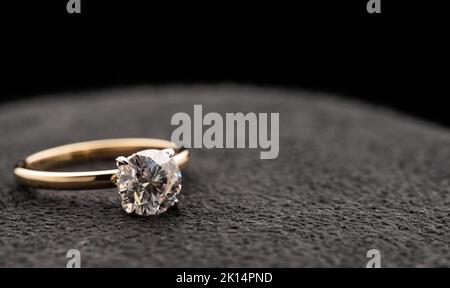 Gold Engagement Diamond Ring on Natural Black Stone Stock Photo
