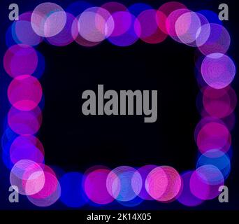 Blurred purple and blue christmas lights frame on dark background Stock Photo