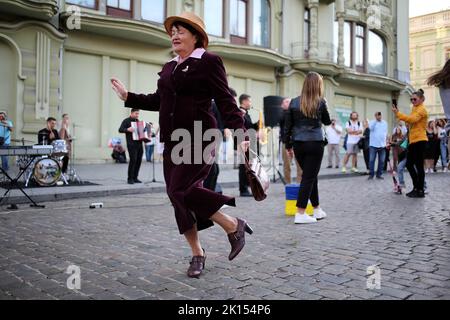 Odessa, Ukraine. 15th Sep, 2022. A woman is seen dancing to the music of a street band. Despite the full-scale invasion of the Russian Federation, on the weekends, joy and life reign on the main street of Odessa - Deribasovskaya, vacationers walk, dance, having fun, as in peacetime. Deribasovskaya street - one of the central streets of the city of Odessa, is one of the main attractions of the city.Since the end of the 20th century, most of Deribasovskaya has been closed to traffic and is a pedestrian zone. Deribasovskaya is a popular place for festivities. There are numerous cafes and sho Stock Photo