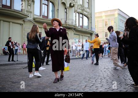 Odessa, Ukraine. 15th Sep, 2022. A woman is seen dancing to the music of a street band. Despite the full-scale invasion of the Russian Federation, on the weekends, joy and life reign on the main street of Odessa - Deribasovskaya, vacationers walk, dance, having fun, as in peacetime. Deribasovskaya street - one of the central streets of the city of Odessa, is one of the main attractions of the city.Since the end of the 20th century, most of Deribasovskaya has been closed to traffic and is a pedestrian zone. Deribasovskaya is a popular place for festivities. There are numerous cafes and sho Stock Photo