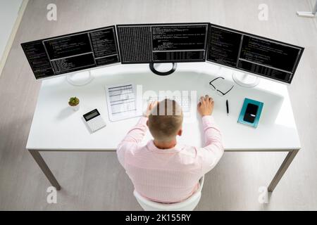 Computer Programmer Writing Program Code On Computer In Office Stock Photo