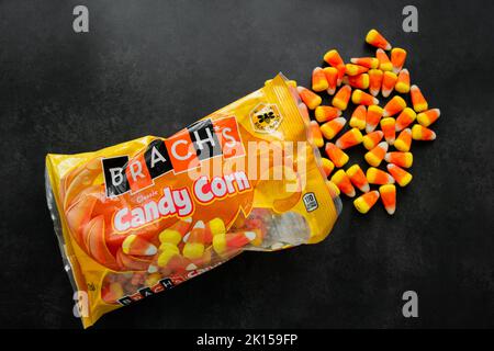 Moscow, Russia, September 2021: Candy corn candies spilled out of pack. Traditional sweets on Halloween. Treat or trick. Copy space. Stock Photo