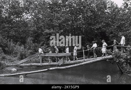 Decoration Day in the Blue Ridge Mountains near Banner Elk, NC, is celebrated by this family annually. They visit their family's cemetery and decorate the graves in a long-held tradition. This picture was taken as the family crosses a stream, heading to the graves. Stock Photo