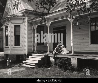 In the summer of 1960, 10 year-old Mike, a boy from Maxton, NC, a small town halfway between Charlotte and WIlmington on US 74, plays with friends on a porch. The porch was a common place for kids to play in the era before television dominated. Mike grew up and served in Vietnam, returning with a bride. Stock Photo