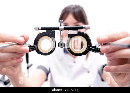 From above of crop unrecognizable ophthalmologist with optical trail lens frame standing in modern optic office Stock Photo