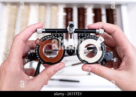 From above of crop unrecognizable ophthalmologist with optical trail lens frame standing in modern optic office Stock Photo