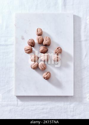 Opening walnuts with a cracker top view. White background Stock Photo