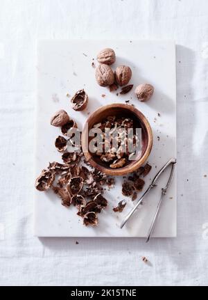 Opening walnuts with a cracker top view. White background Stock Photo