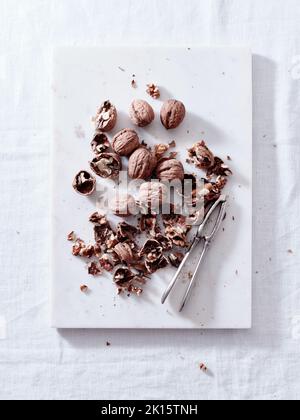 Opening walnuts with a cracker top view. White background Stock Photo