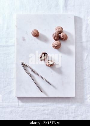 Opening walnuts with a cracker top view. White background Stock Photo