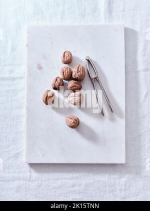 Opening walnuts with a cracker top view. White background Stock Photo