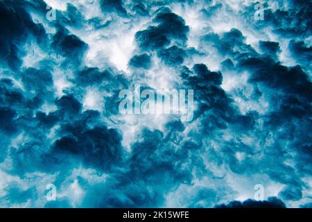 From below dark blue clouds covering sky in stormy evening on Thulusdhoo Island, Maldives Stock Photo