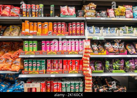 Supermarket shelf filled with unhealthy crisps and savory snacks Stock Photo