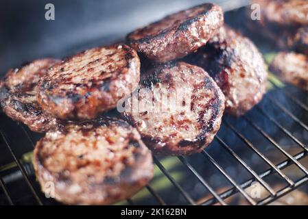 Grilled beef burger patties on a BBQ Stock Photo