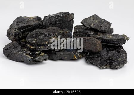 Black coal lumps isolated on white background. Fossil fuel, air pollution and coal mining industry concept. Stock Photo